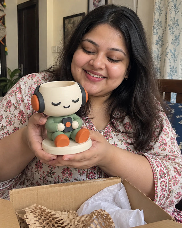 A MiniKin customer smiling at a newly unboxed Headphone Planter