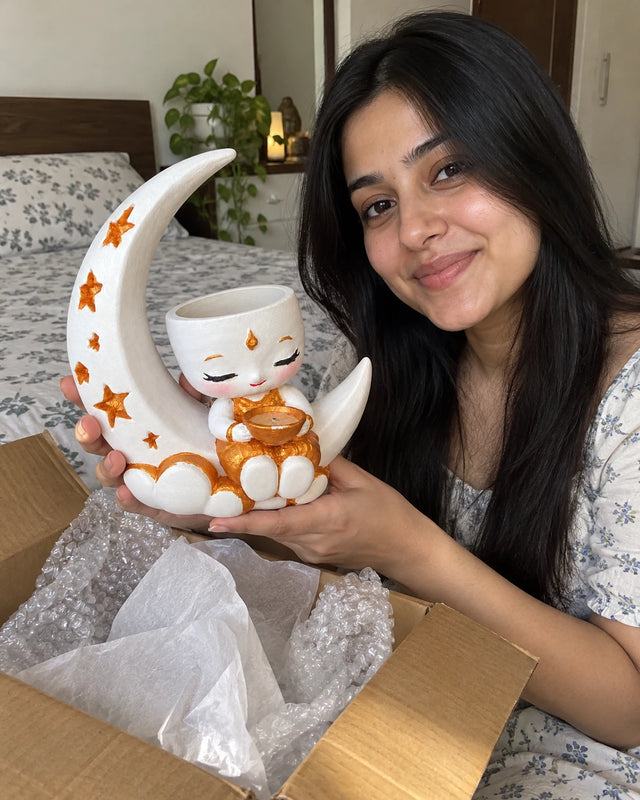 A MiniKin customer holding a Festival Moon Planter beside its delivery box