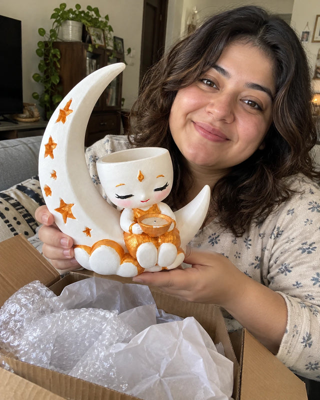 A MiniKin customer smiling with a newly unboxed Festival Moon Planter